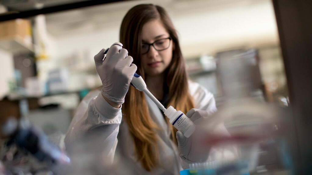 chemistry student in a lab performing an experiment