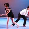 Two dancers perform on stage.